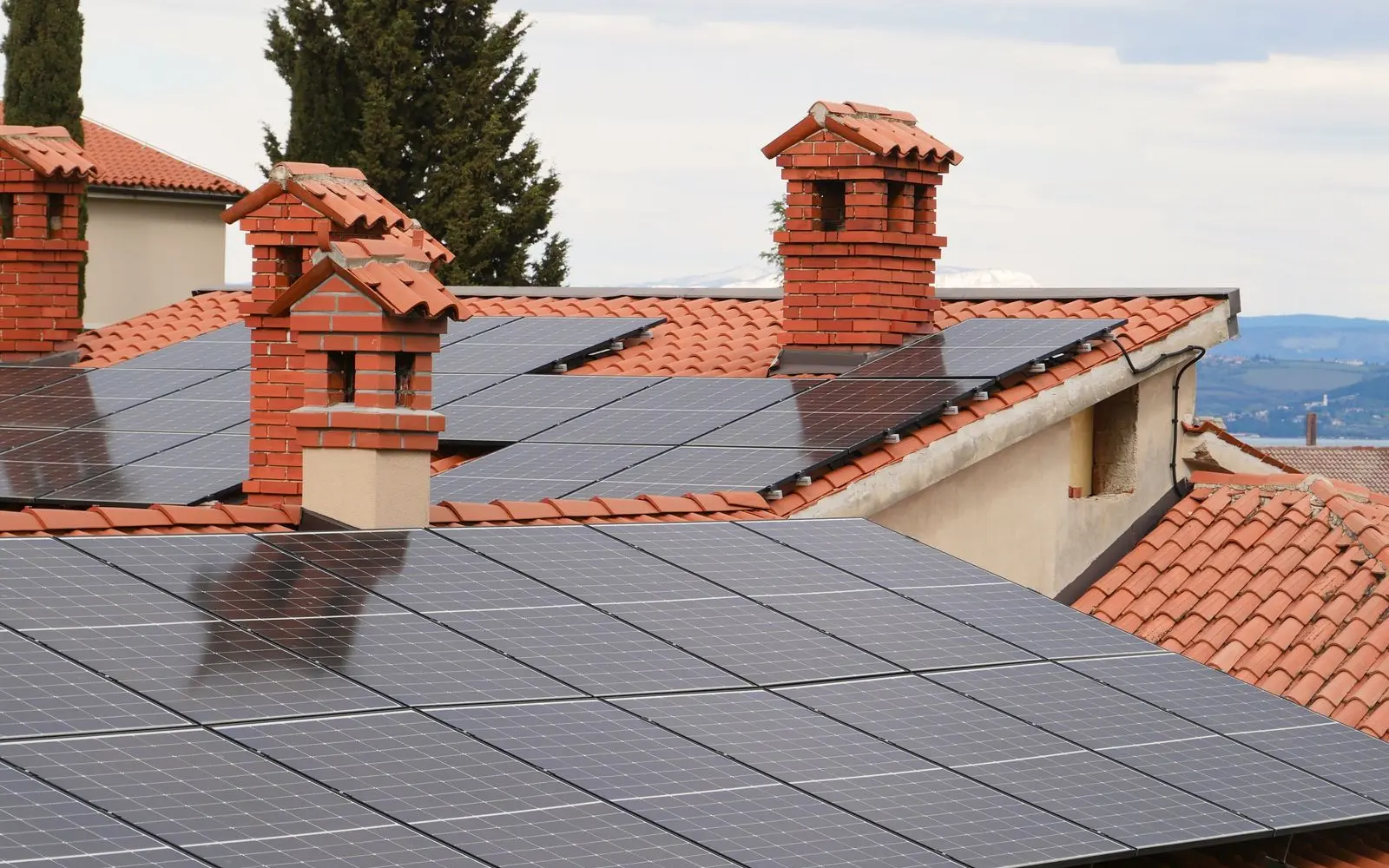 Photovoltaikmodule auf roten Hausdächern zur Erzeugung von Solarstrom